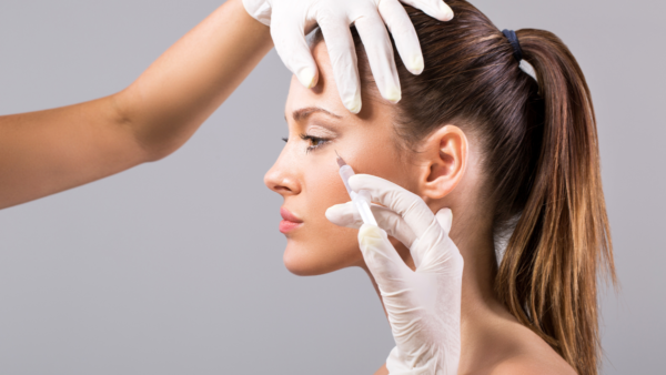Woman receiving cosmetic injection on her face