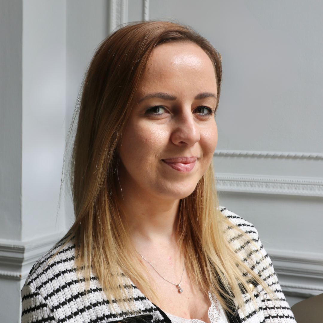photo of a woman in a black and white striped top wearing a necklace.