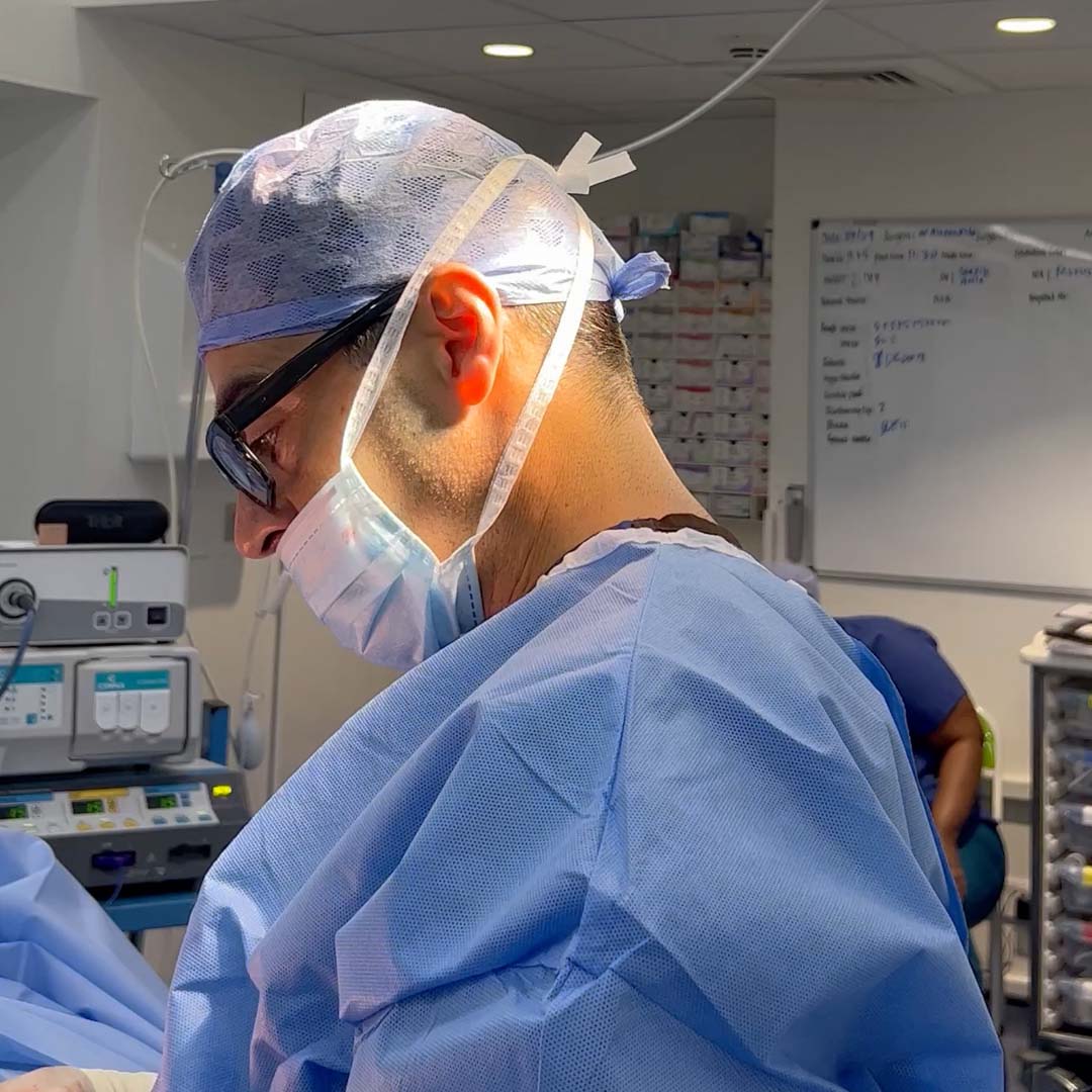A surgeon wearing a surgical hat and mask