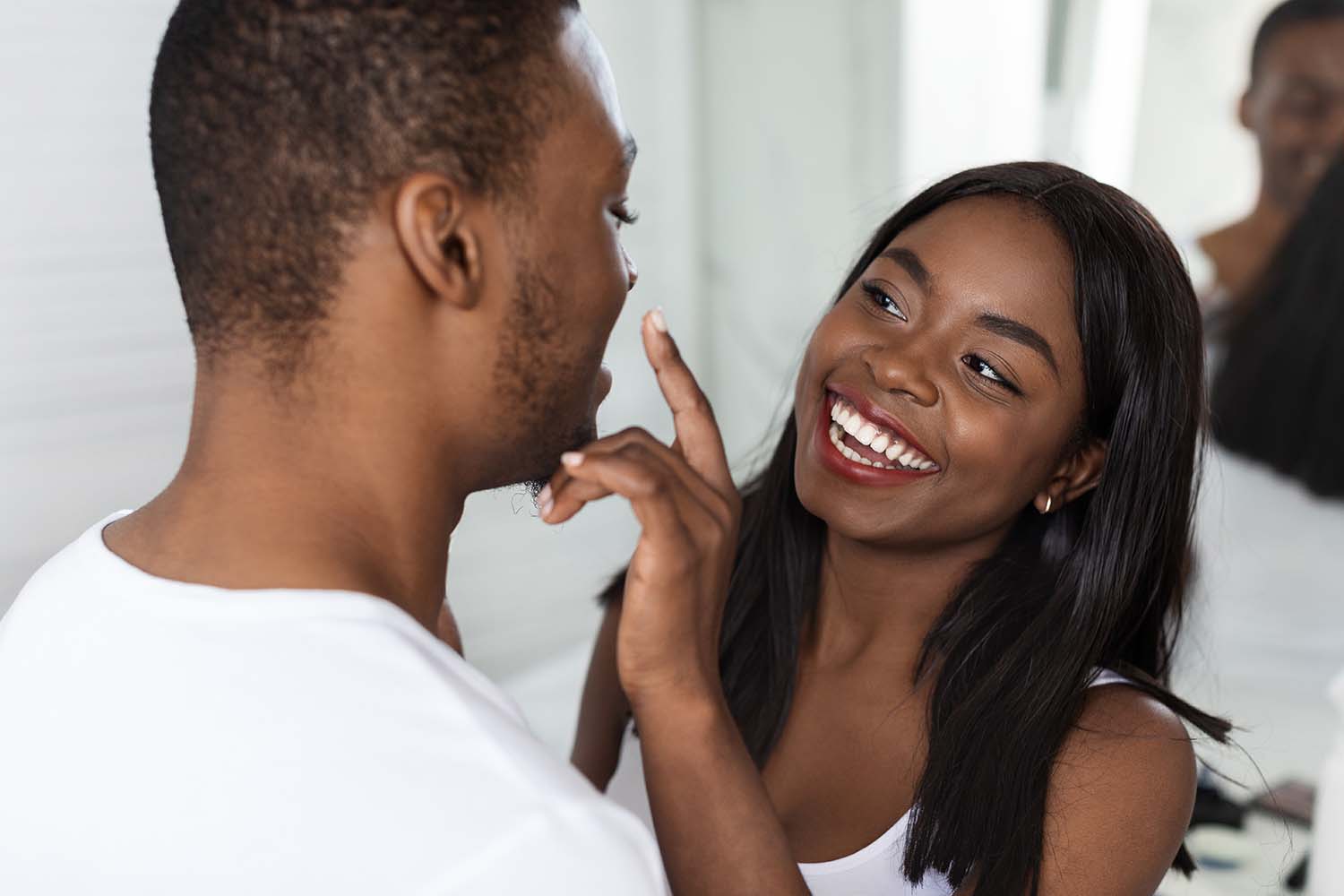 A woman is touching a man's nose