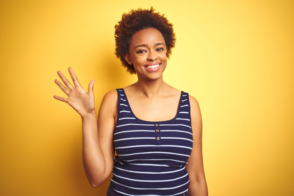 woman waving in yellow background