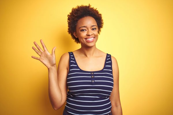woman waving in yellow background