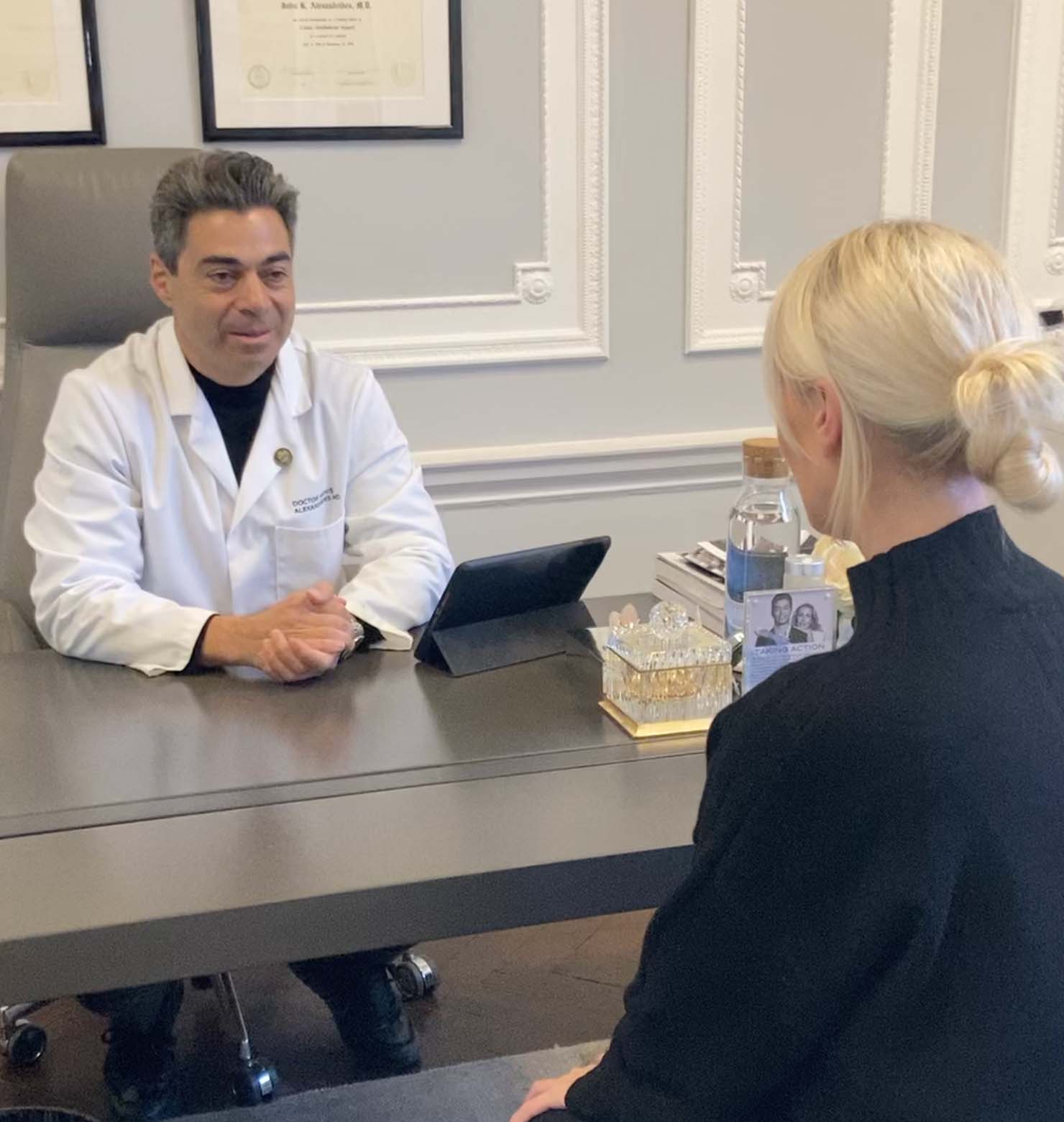 A Doctor sits across from a woman at a desk