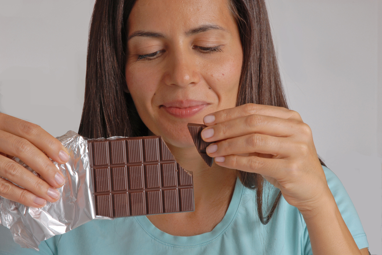 woman break dark chocolate bar