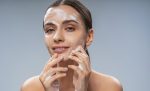 Smiling pretty woman washing her face with soap
