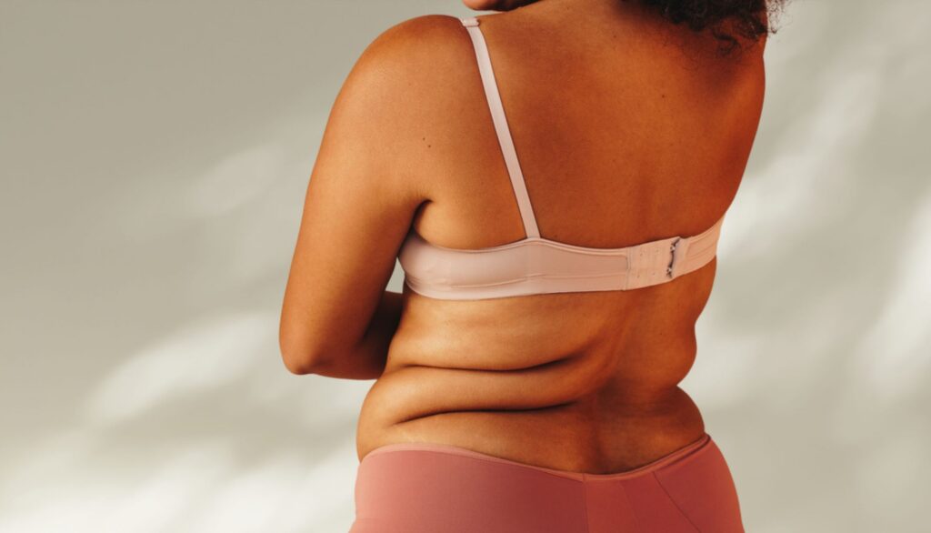 Back view of a happy curvy woman wearing underwear