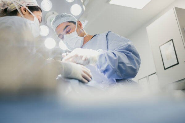 Masked and gloved surgeons are engaged in a medical procedure 