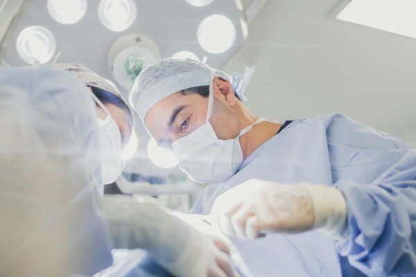 Close up Surgeon in blue scrubs during surgical operation
